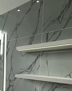 White marble wall with fluted panels and an LED-lit fire, built by WK Home Interiors