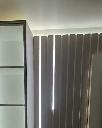 Grey fluted wall with lit glass display cabinets, built by WK Home Interiors