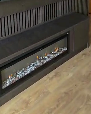 Long built-in fire set into a dark slatted media unit on an oak floor