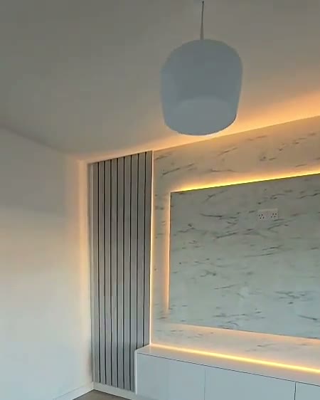 Marble feature wall with fluted column, lit at dusk, built by WK Home Interiors